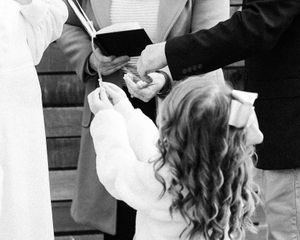 bride's daughter brings up the rings for the bride and groom