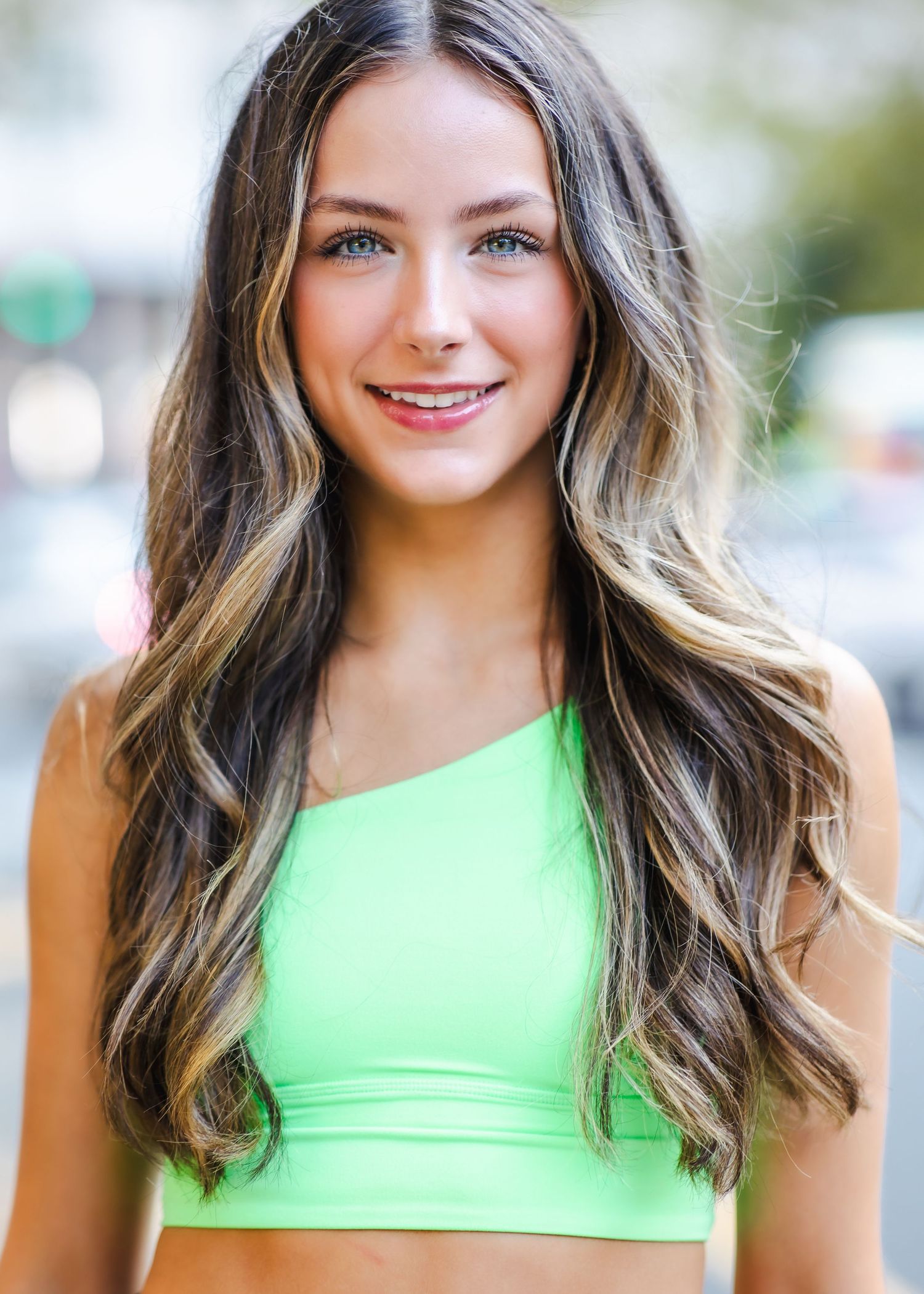 Athletic portrait in neon green fitness top with soft natural lighting.