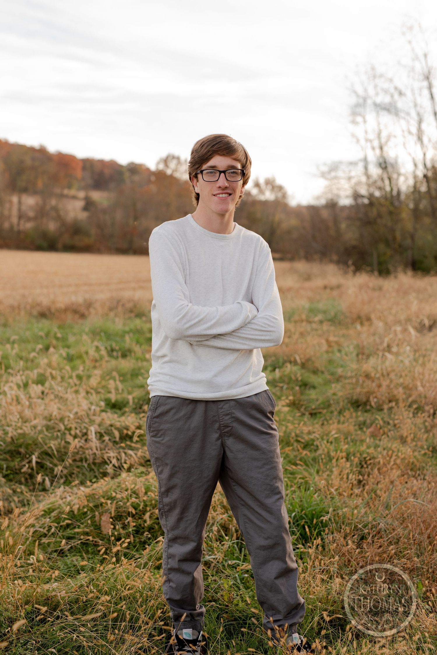 Outdoor casual portrait with crossed arms in autumn field.