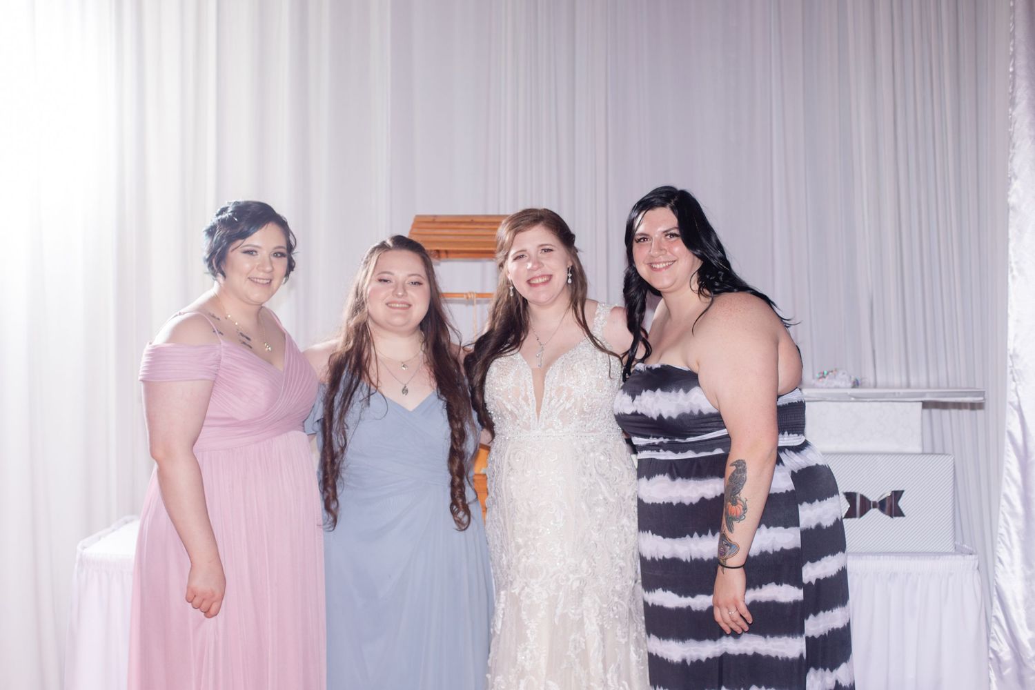 Wedding party members gathered at reception venue in formal attire.