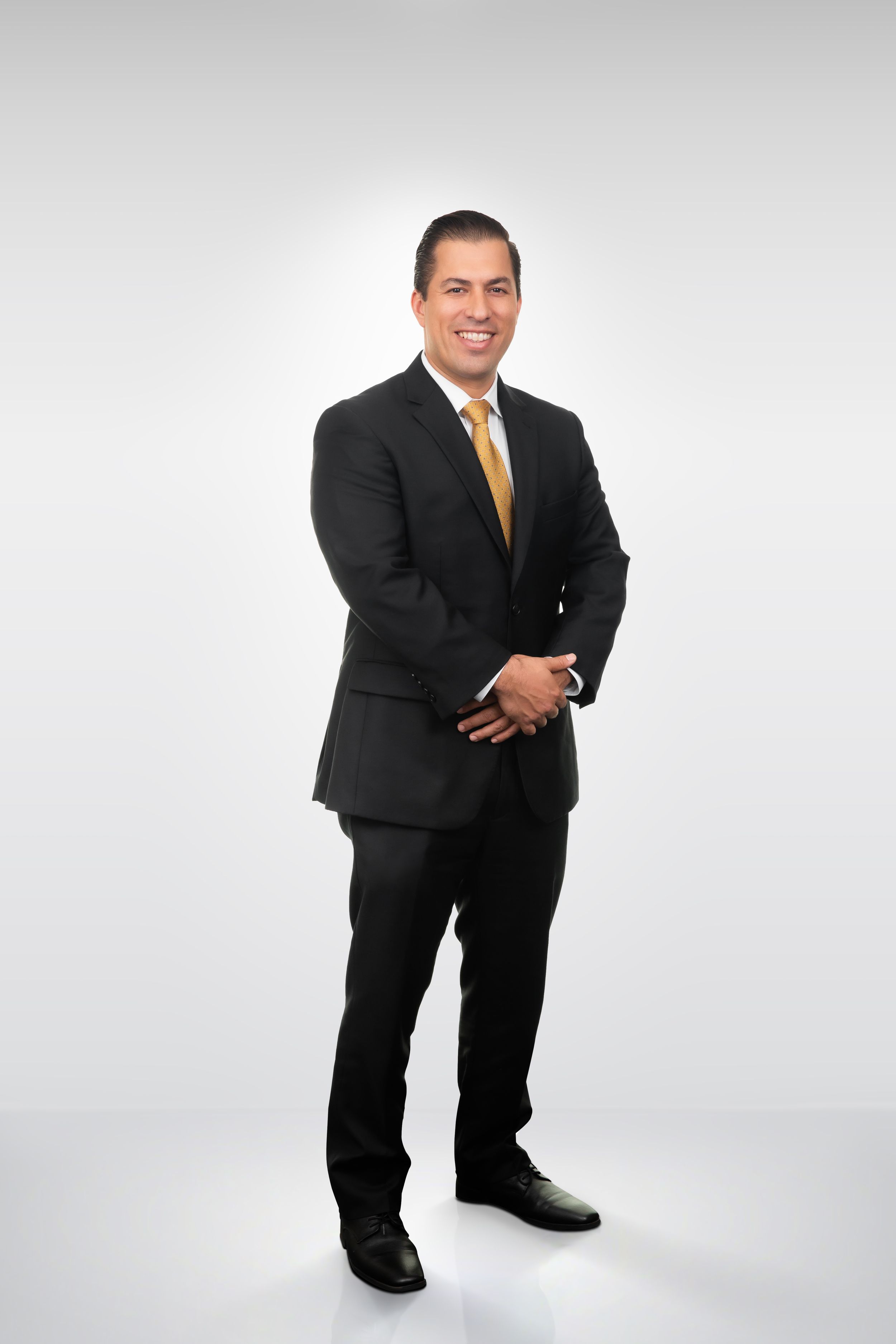 Professional in black suit strikes various poses against white background.