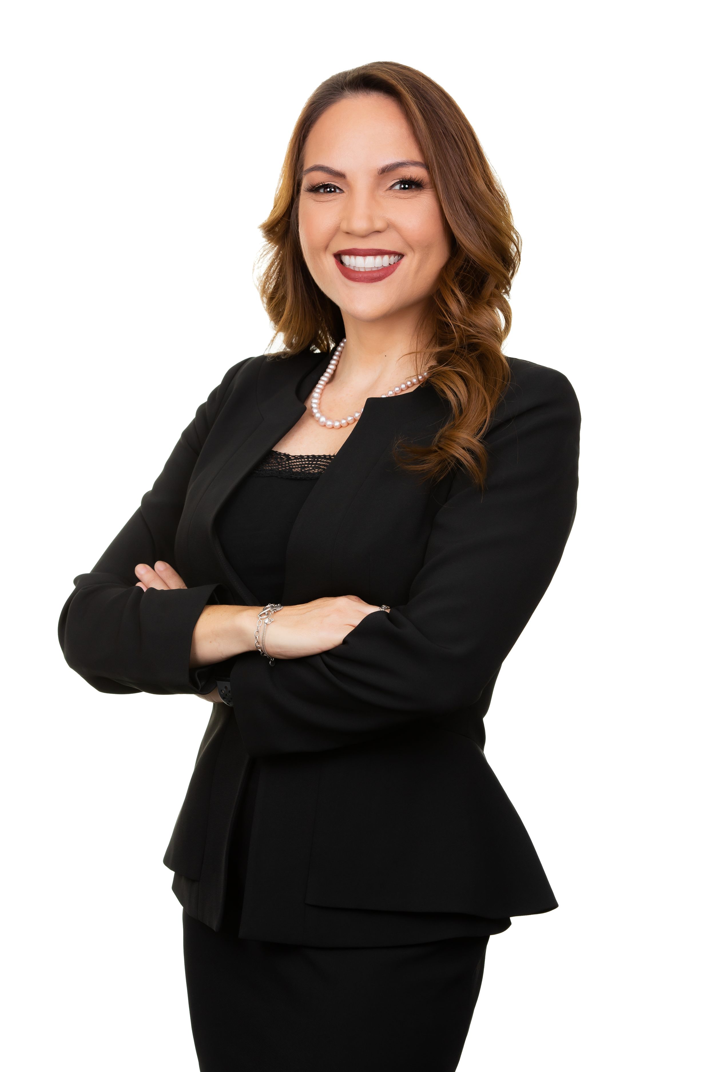 Professional woman in black business attire poses confidently against white background.