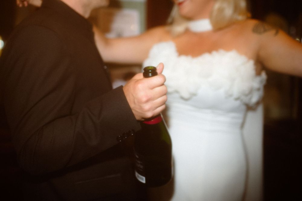 A couple shares a celebratory moment with champagne at their wedding reception.