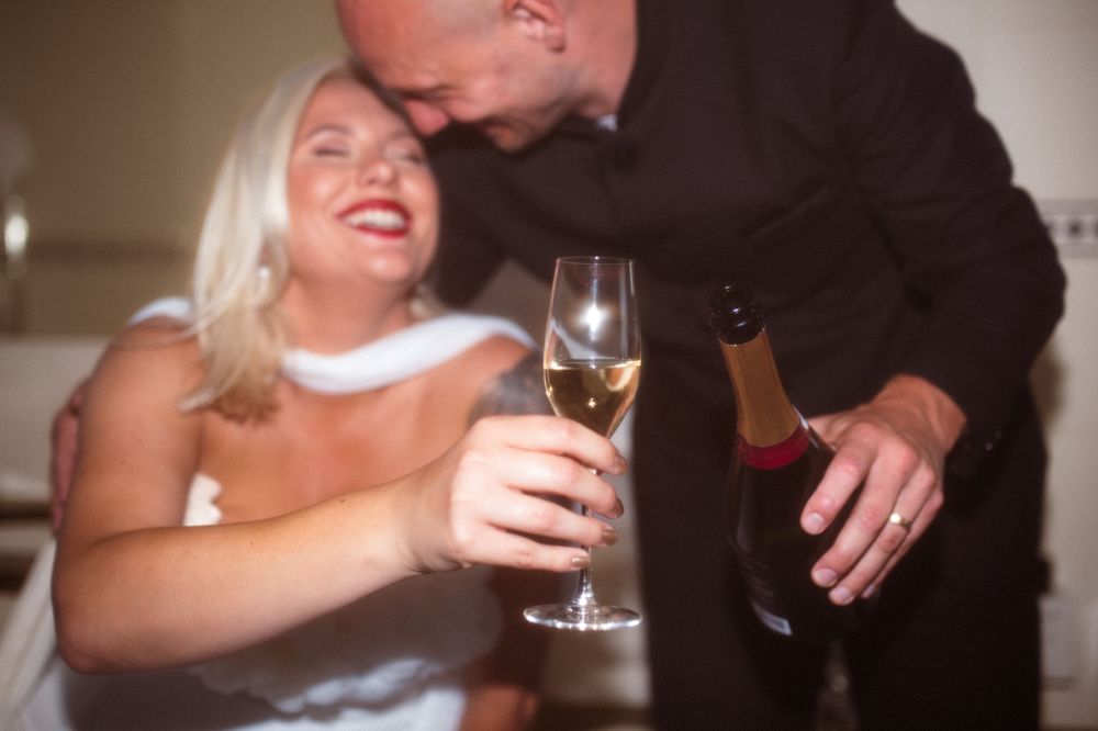 Couple shares laughs while toasting with champagne glasses.