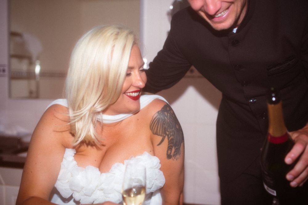 Couple shares intimate moment while celebrating with champagne.