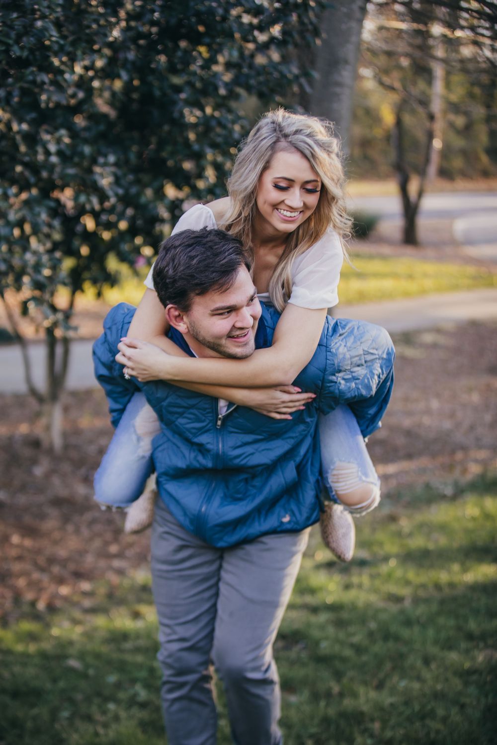 couple laughs during a piggy back ride