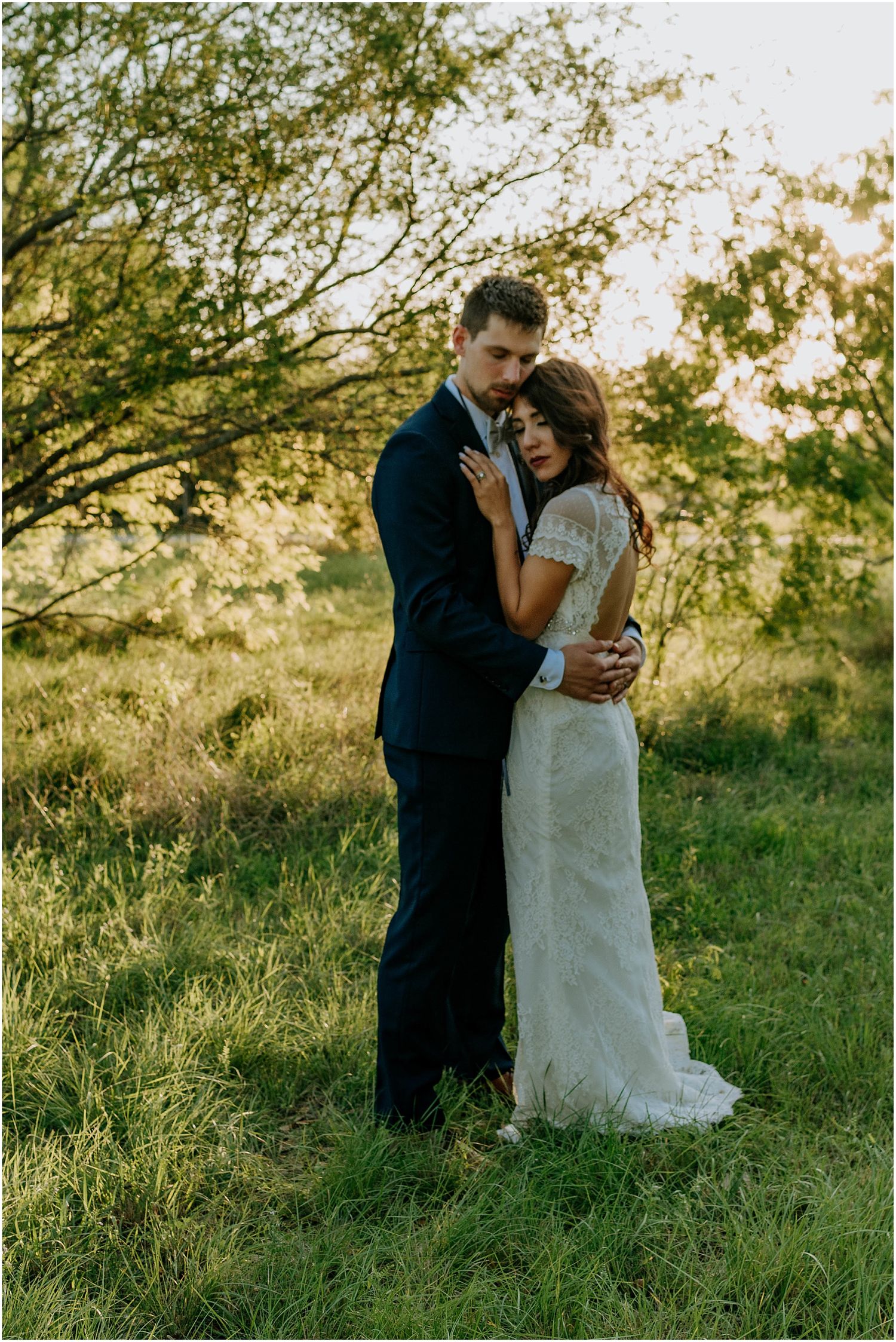 Tender embrace captured in outdoor wedding photography with golden hour lighting.