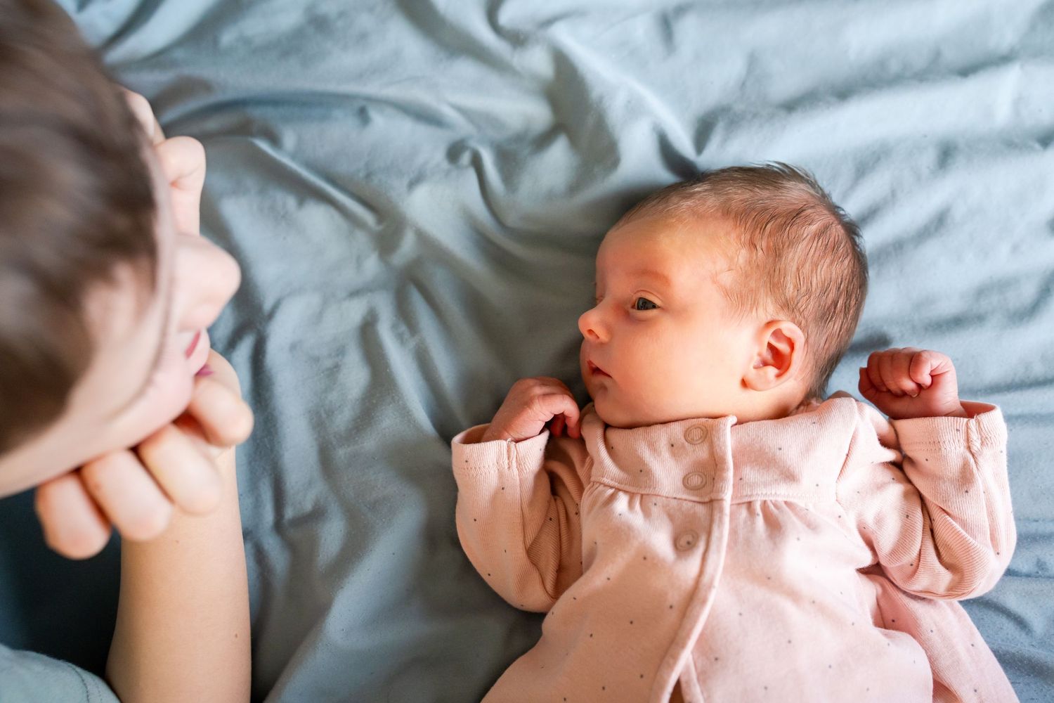 baby sister looking up at brother
