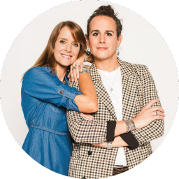 Casual portrait of two people in contrasting outfits against white background.