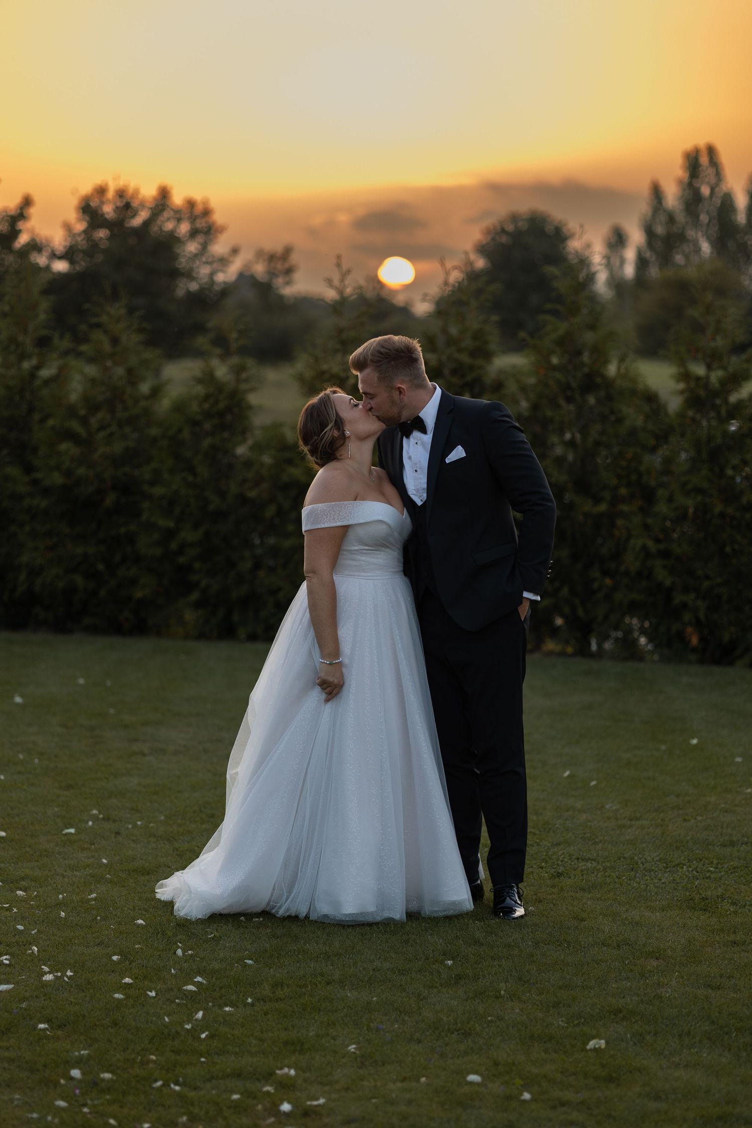 Bride and Groom kissing in front of sunset on their wedding day in Essex, UK