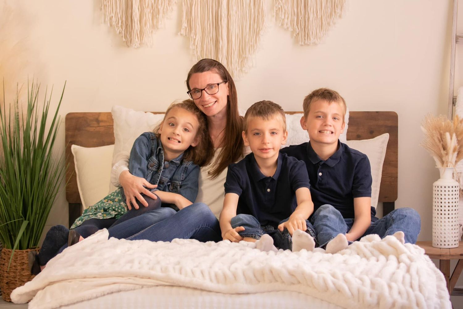 mother sitting on bed with her 3 children