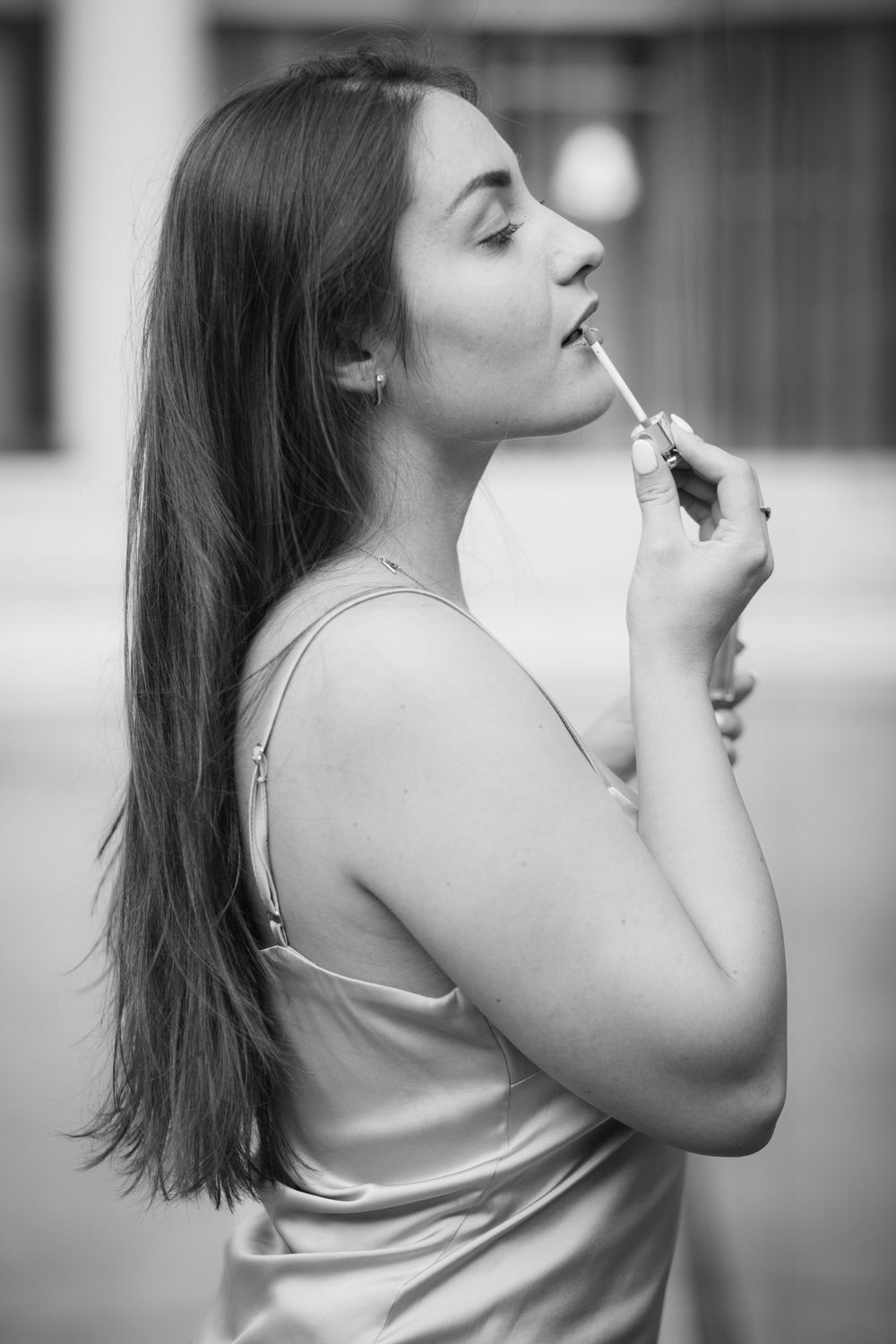 Gorgeous and dreamy photograph of Ukrainian model, Stasia, applying lipstick in black and white