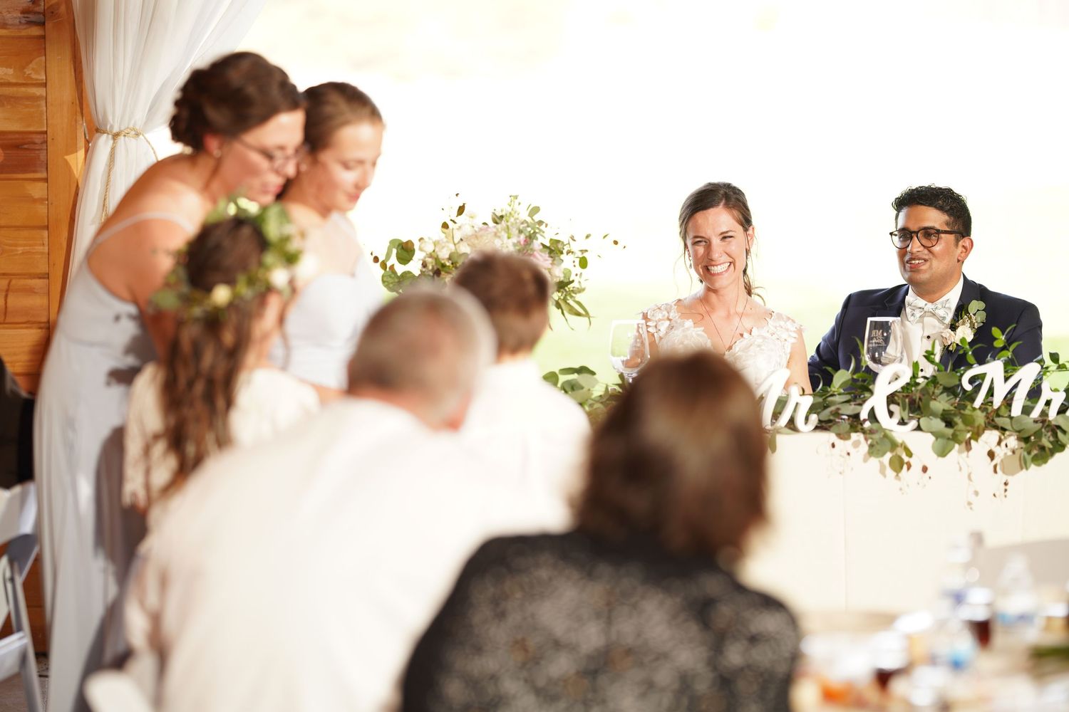 Happy couple looks on as siblings toast their marriage.