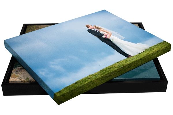 Wedding photo canvas prints stacked showing outdoor portrait against blue sky.