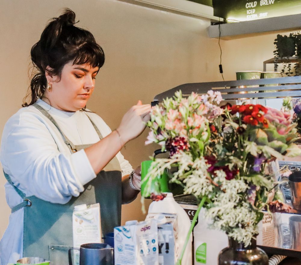A florist arranging a beautiful bouquet of pink and white flowers in a shop.