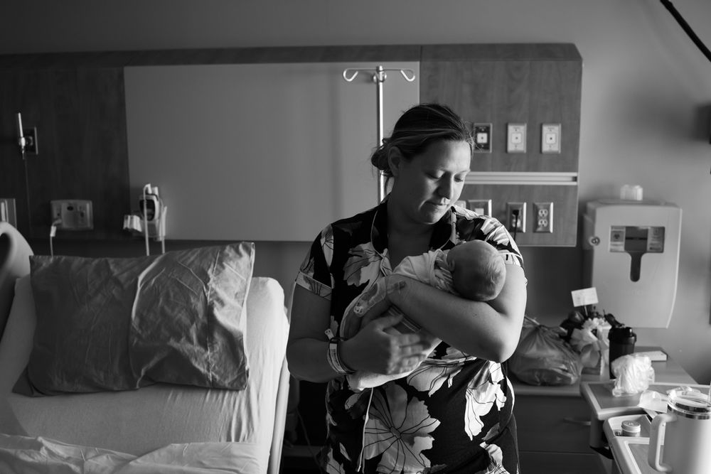 Black and white image of newborn baby being held by her mother.