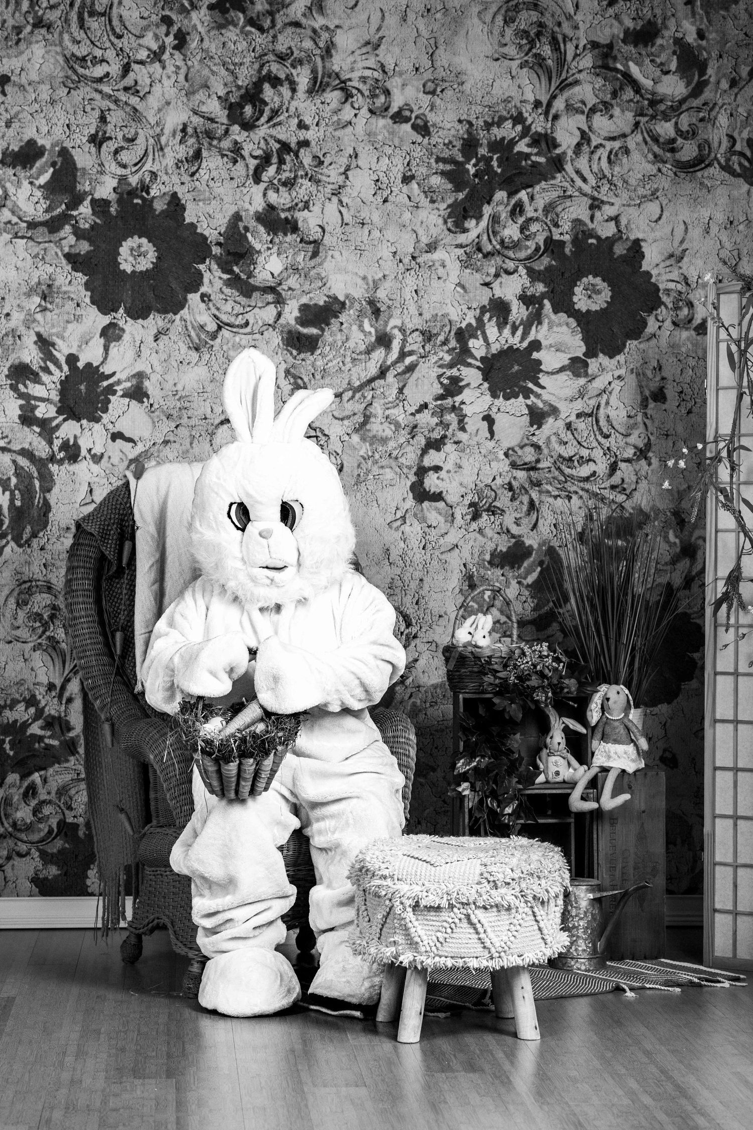 Black and white photo of Easter bunny costume in vintage studio setting.