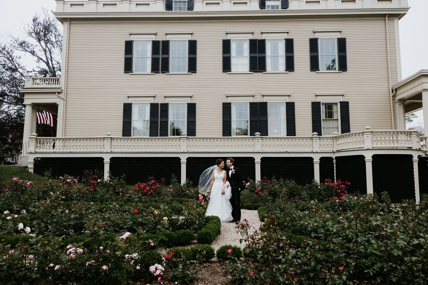 Bride and groom kissing in a rose garden. Rotch Jones Duff House New Bedford, Ma. Miranda Photo & Co