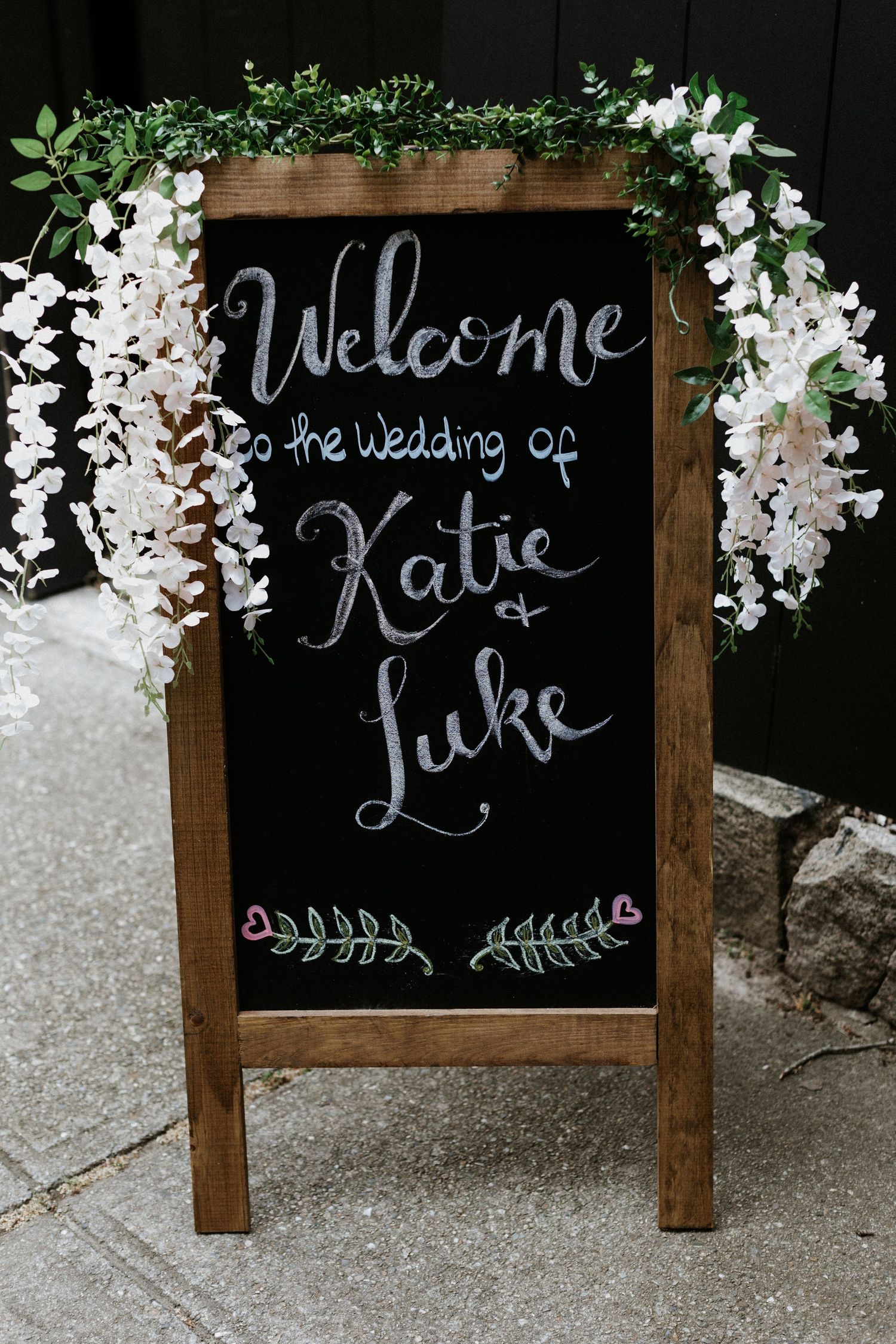 Rustic chalkboard wedding welcome sign decorated with white wisteria flowers for Katie and Luke's wedding. New Bedford, Ma. Miranda Photo &