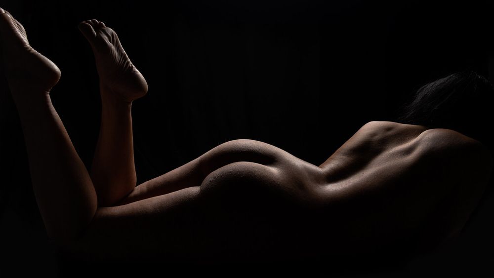 Creative bodyscape photography with dramatic shadows and gentle curves.