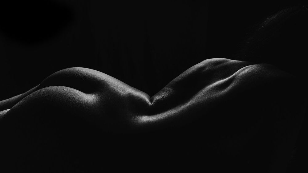 Minimalist nude study in black and white showcasing natural body contours.