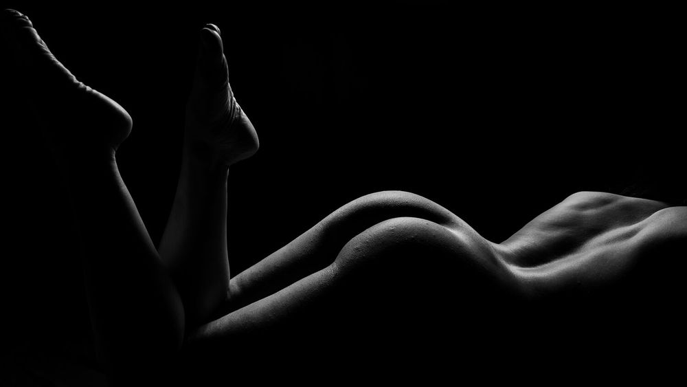 Minimalist nude study emphasizing organic lines and forms in monochrome.