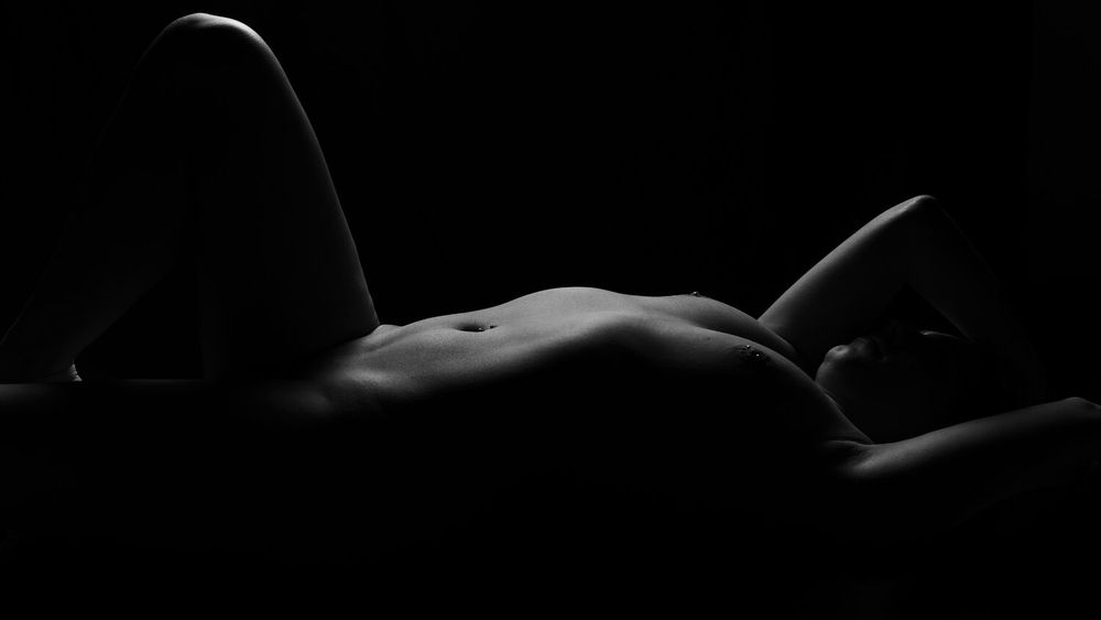 Low key artistic photograph depicting sculptural shapes and shadows.