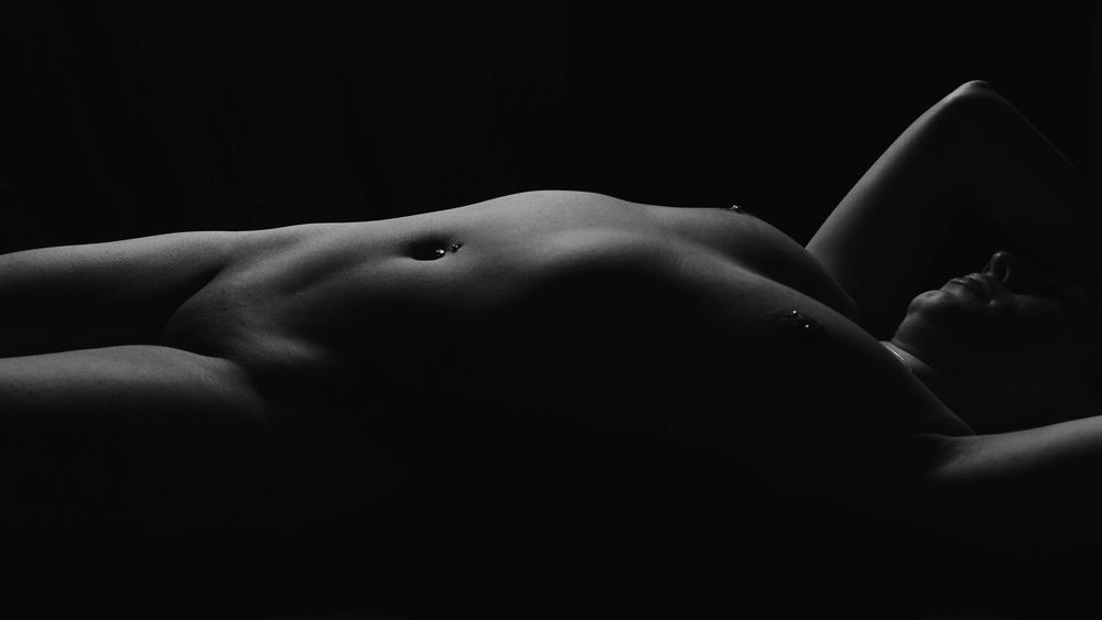 Fine art photography showing dramatic contrast between light and shadow on curved forms.