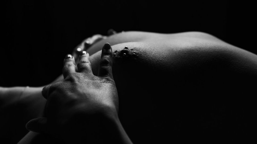 Dramatic black and white photograph showing abstract bodily forms in shadow.