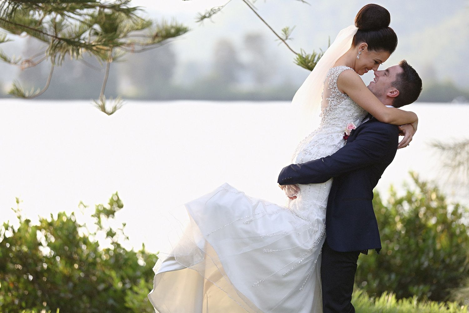 Romantic couple embraces in a garden setting during a wedding photo session.