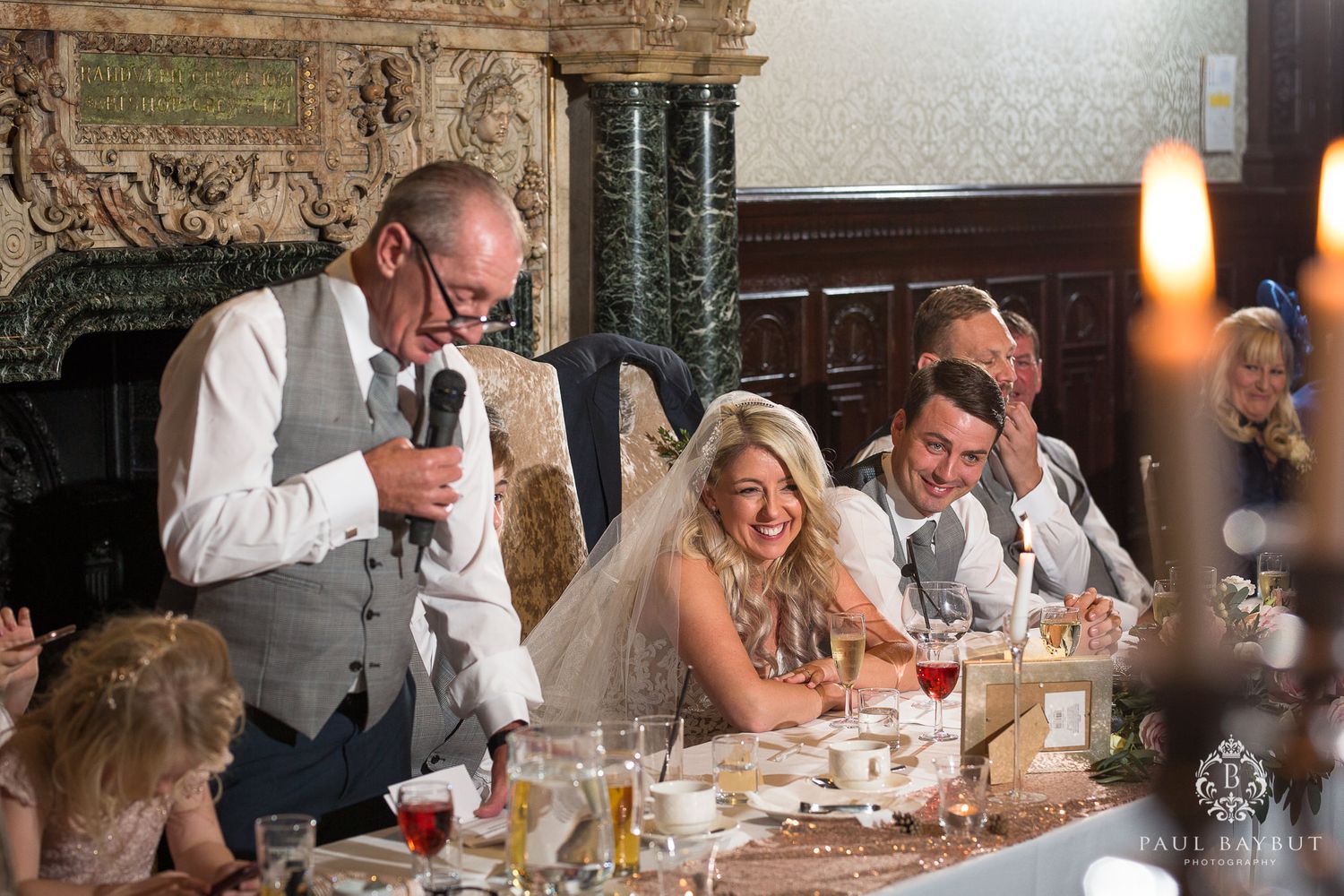 Wedding speeches and toasts during an intimate reception dinner with candlelit ambiance.