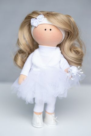 Handmade blonde fabric doll in an all-white tutu outfit with floral headband and white shoes.