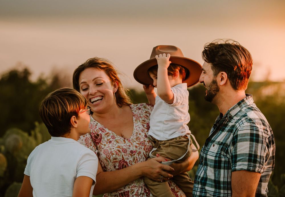 close family smiling with baby wearing hat