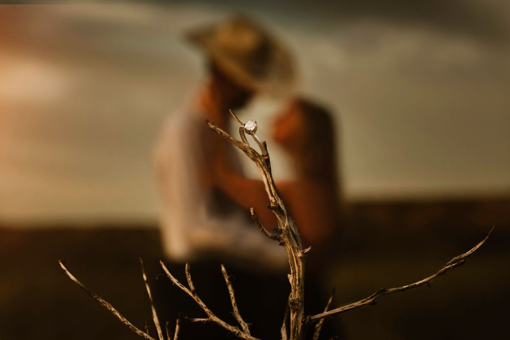 cowboy engagement couple behind wedding ring in focus