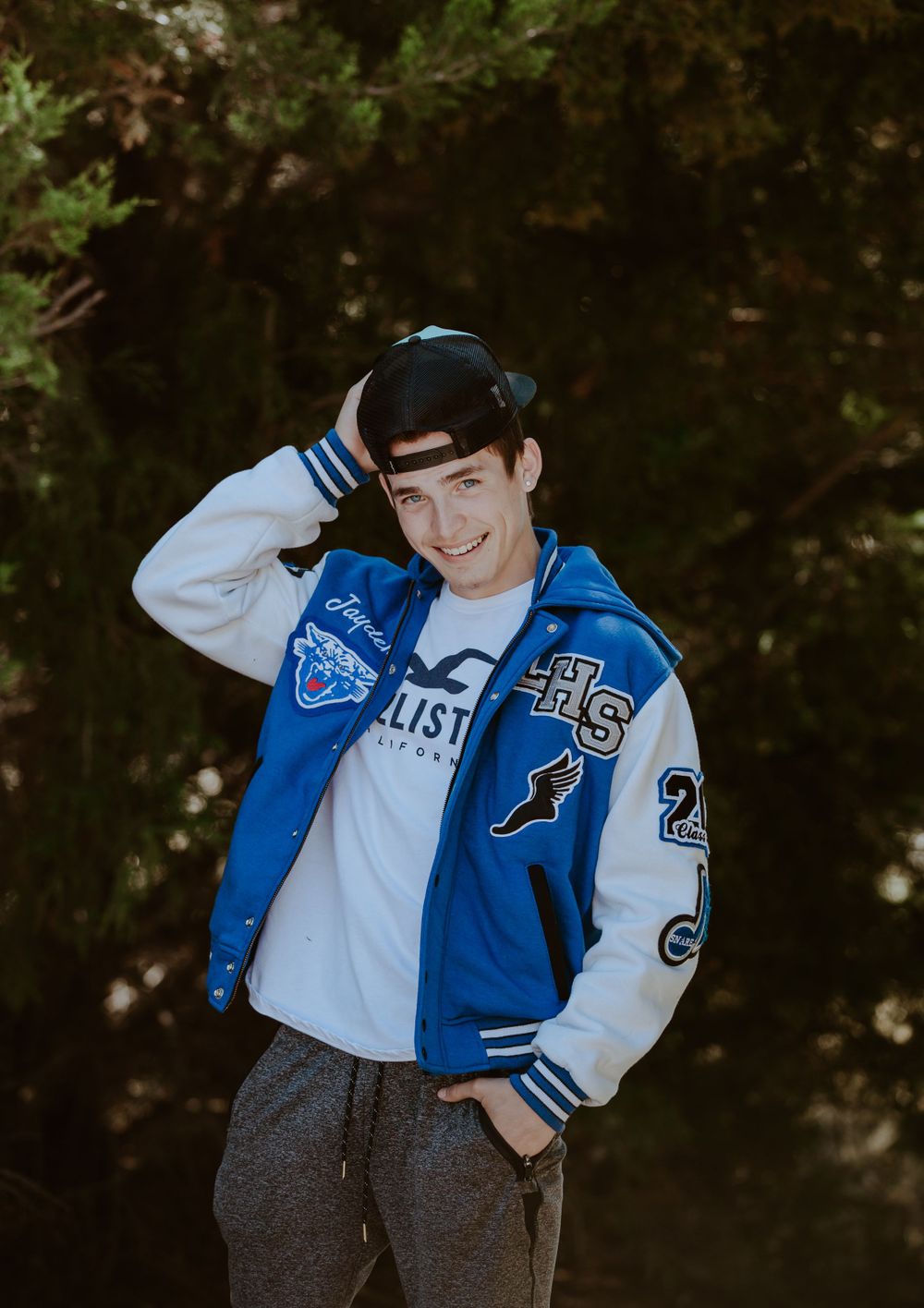 senior wearing a hat and letterman jacket