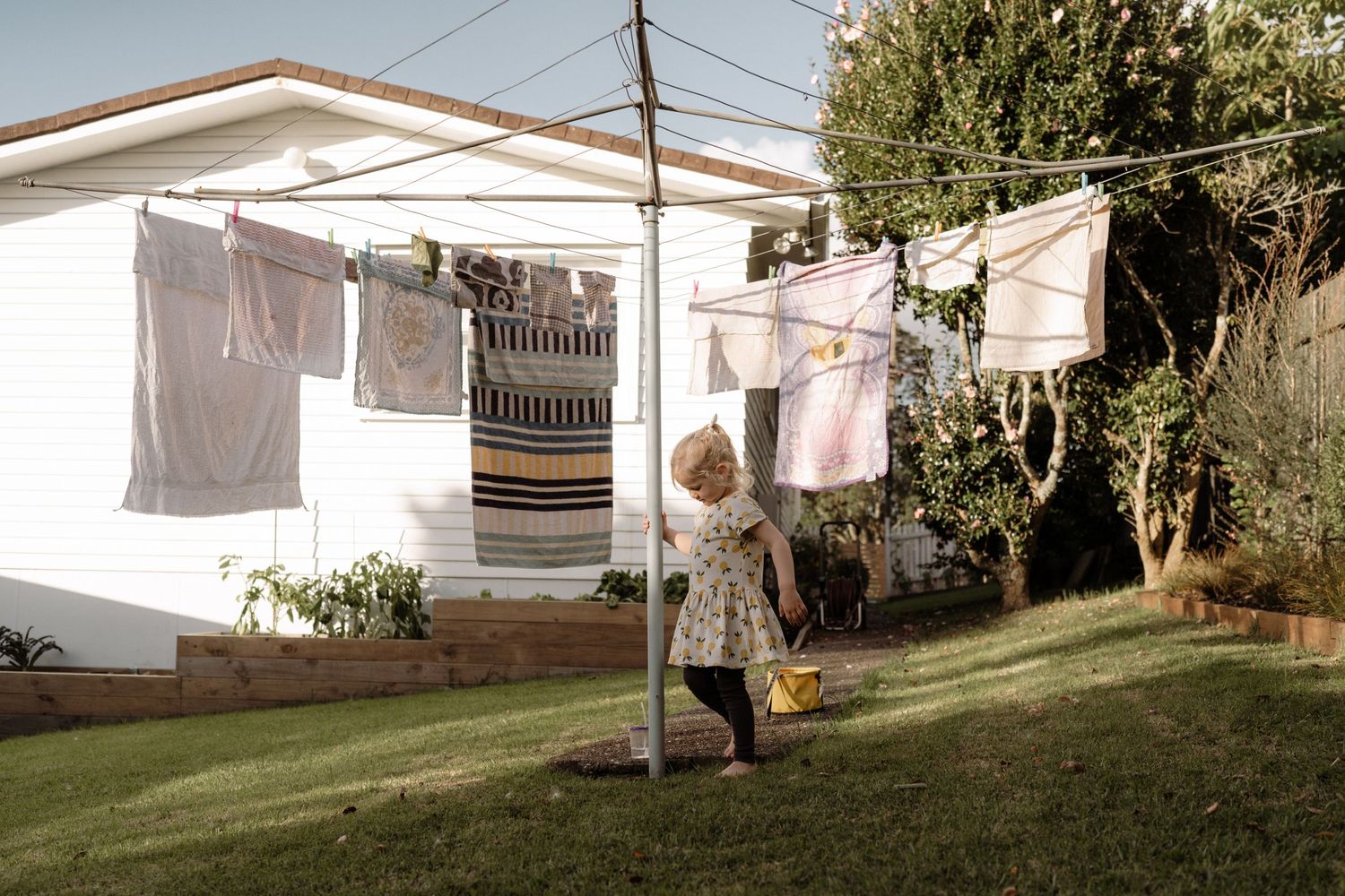 Girl swinging around a washing line.  Auckland central in home family photographer