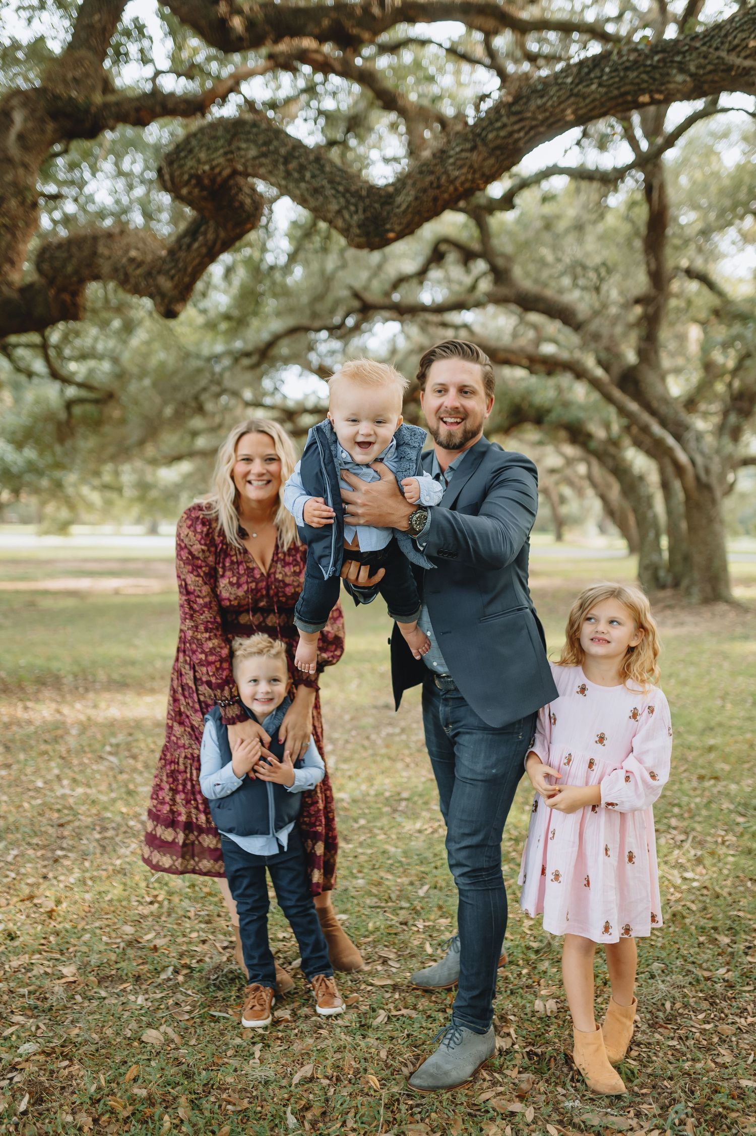 Family gathers under a sprawling oak tree for an outdoor portrait.