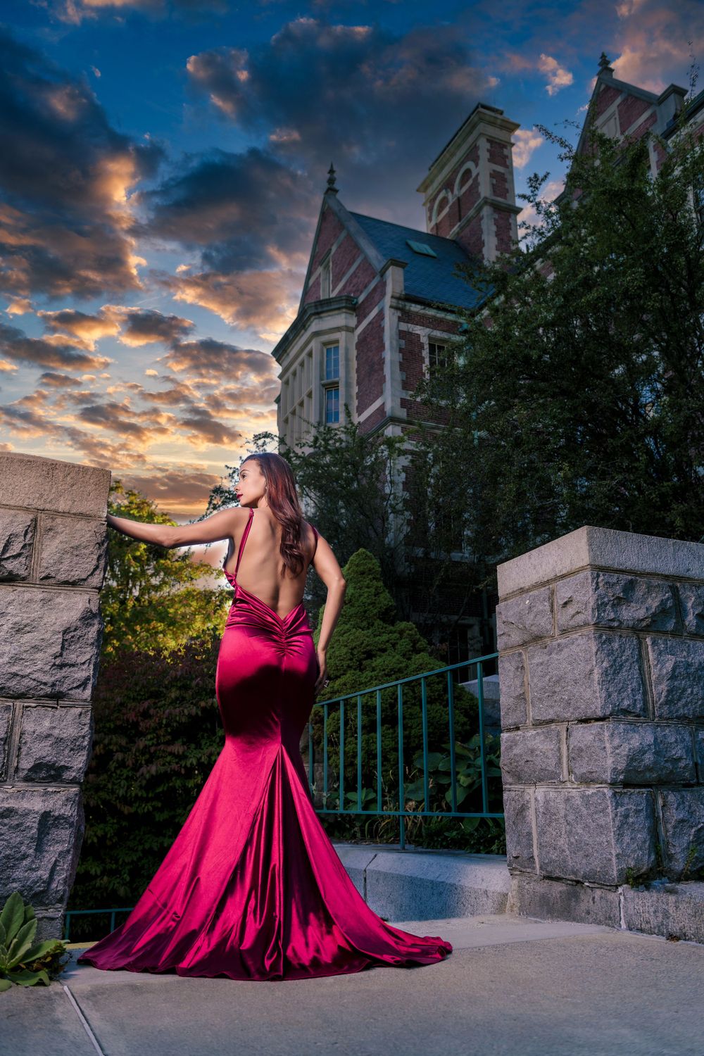 Dramatic magenta gown silhouetted against Gothic architecture during sunset.