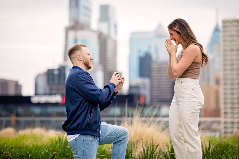 A surprise proposal moment against a city skyline backdrop.