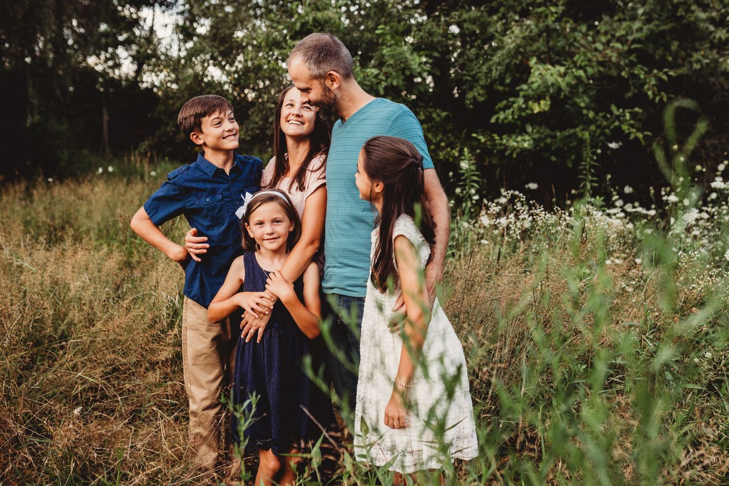 Family smiling with each other in wildflowers