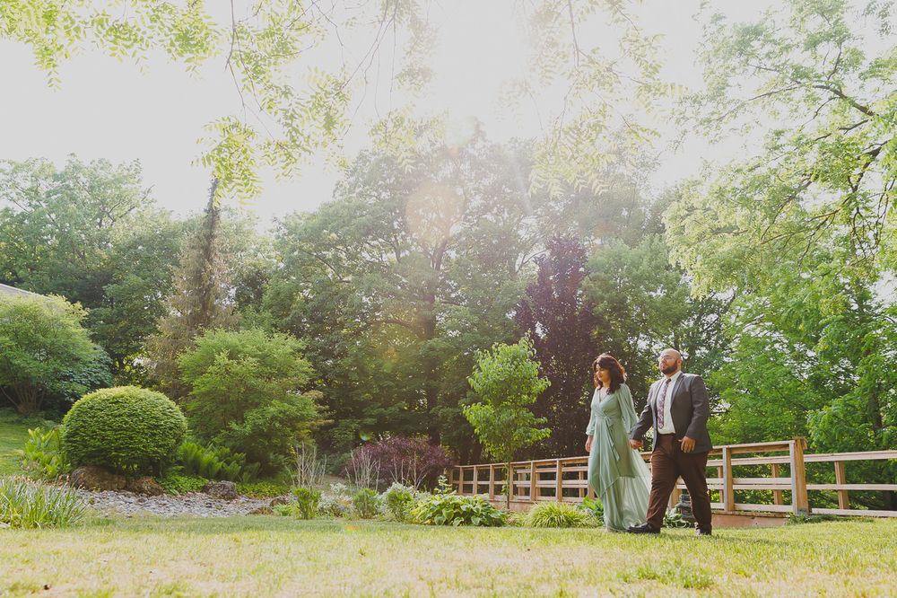 A romantic proposal moment inside a white gazebo surrounded by greenery.