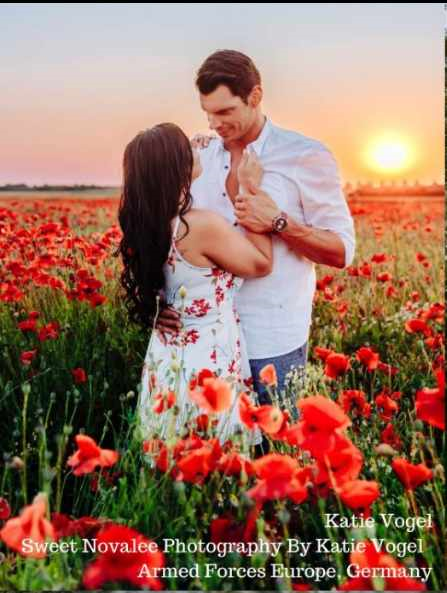 A romantic couple embracing in a field of bright red poppies at sunset.