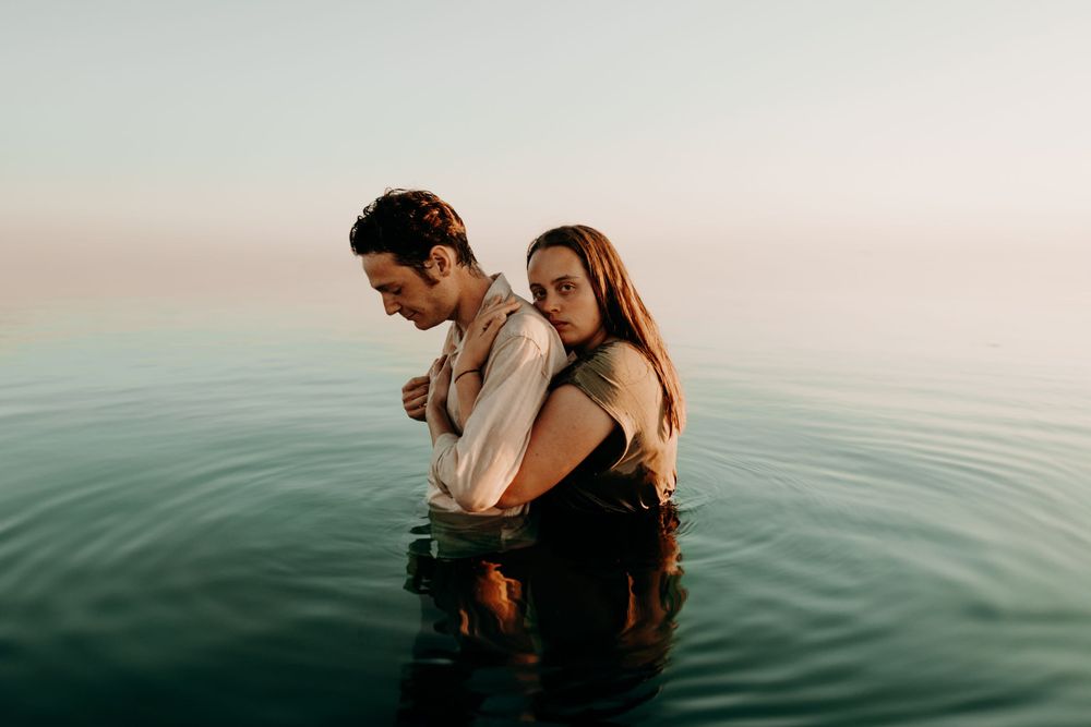 Couple sharing intimate moment while standing in calm turquoise waters.