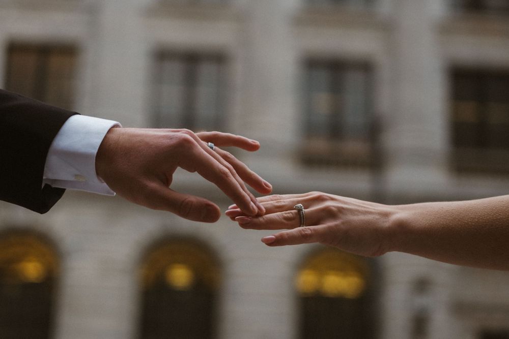 Close-up of hands reaching toward each other in an elegant gesture.