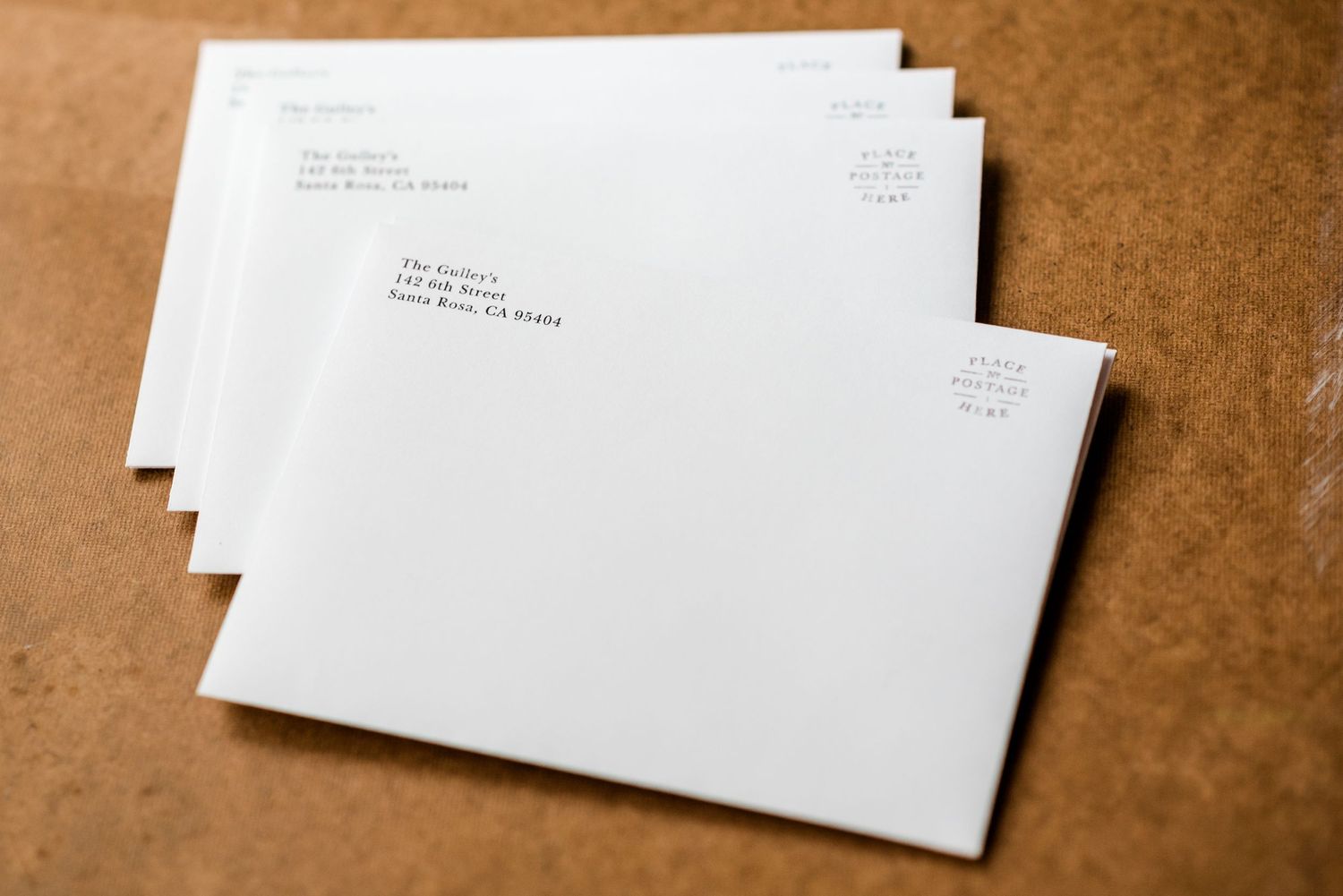 Multiple white envelopes with mailing addresses arranged in overlapping pattern.