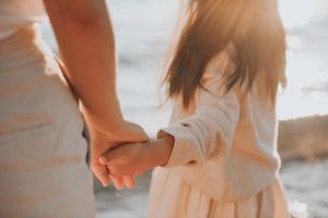 a girl holding mom's hands watching the sunrise of little bay Sydney family photo