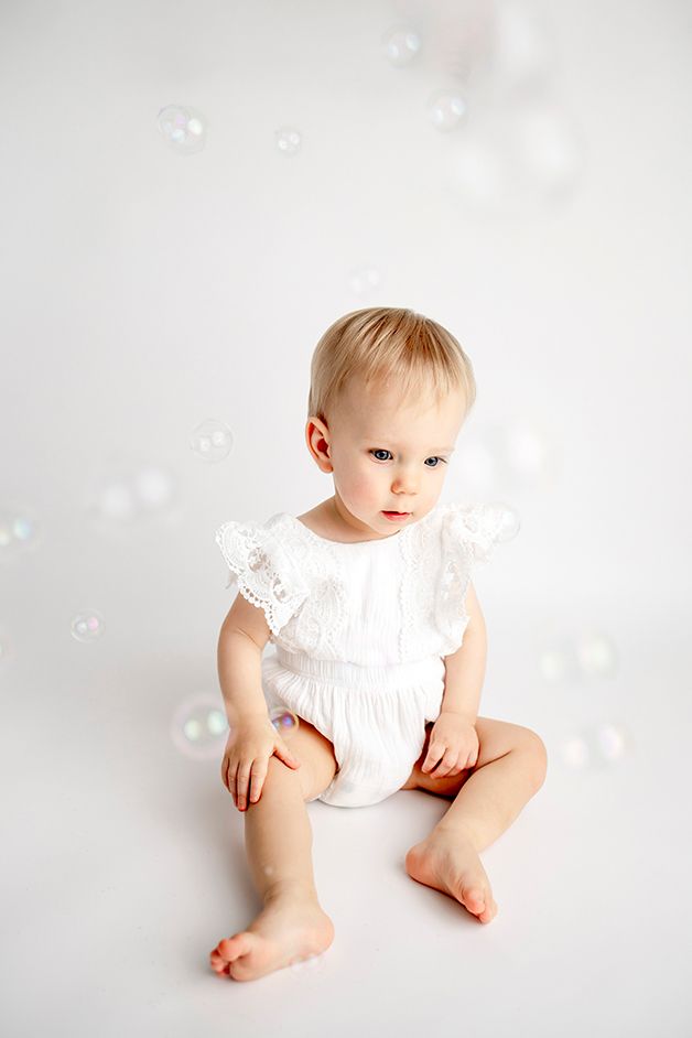 One year old girl looking at bubbles.