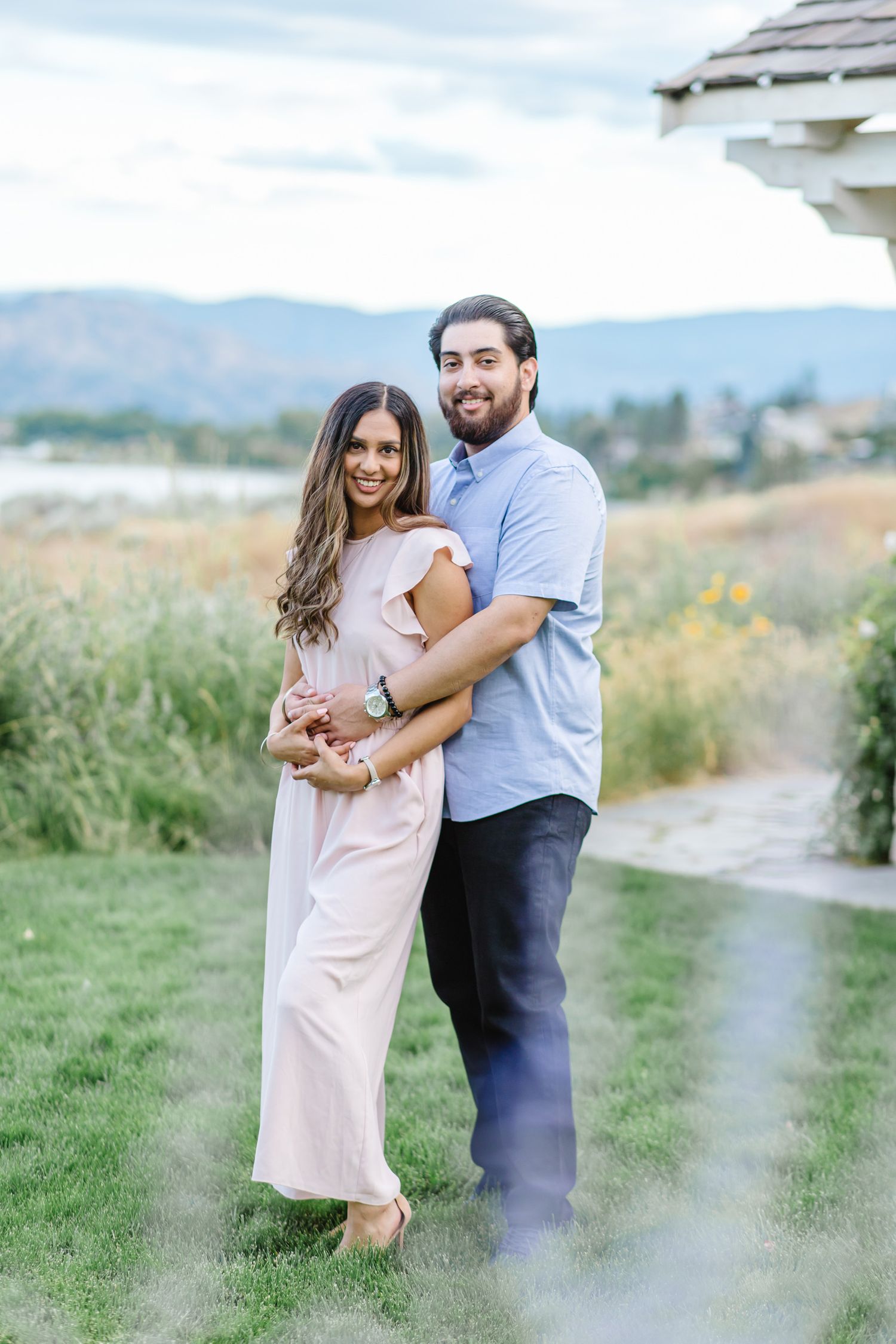 Candid moments captured in a grassy field with mountain views.