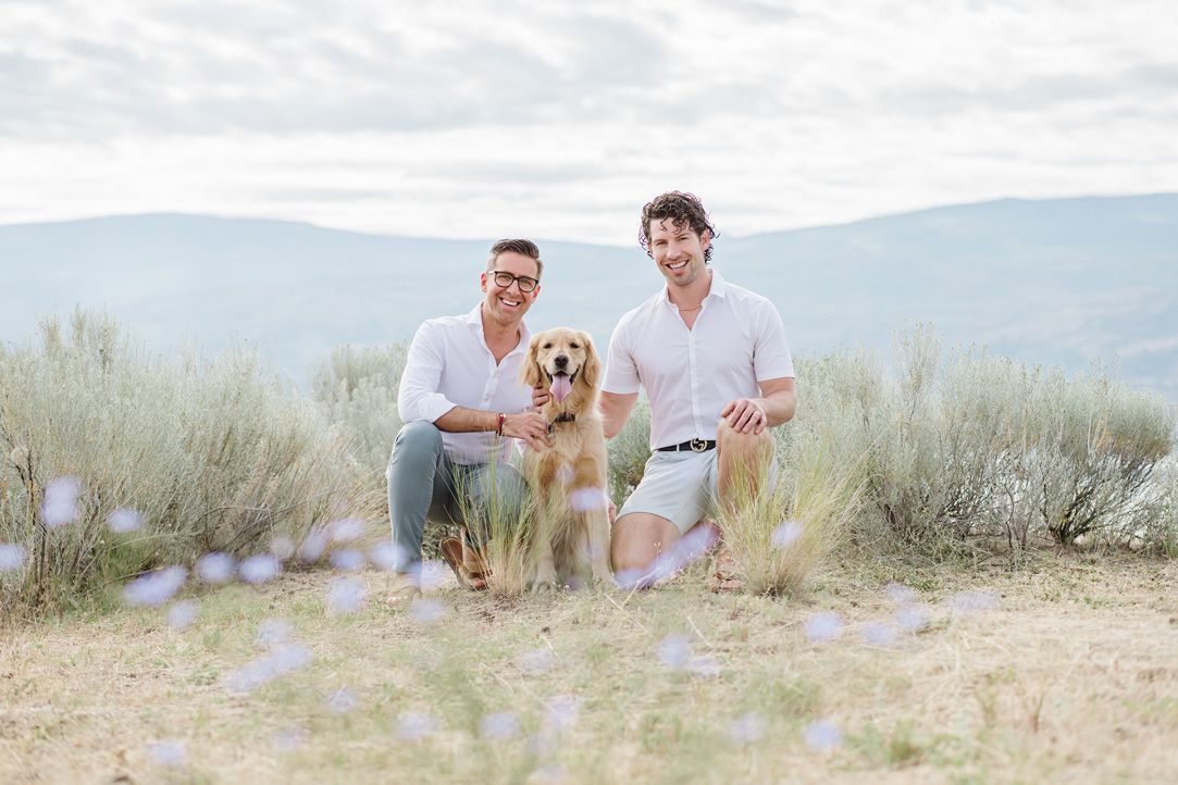 Friends and their dog enjoying a sunny day in nature with mountain views.