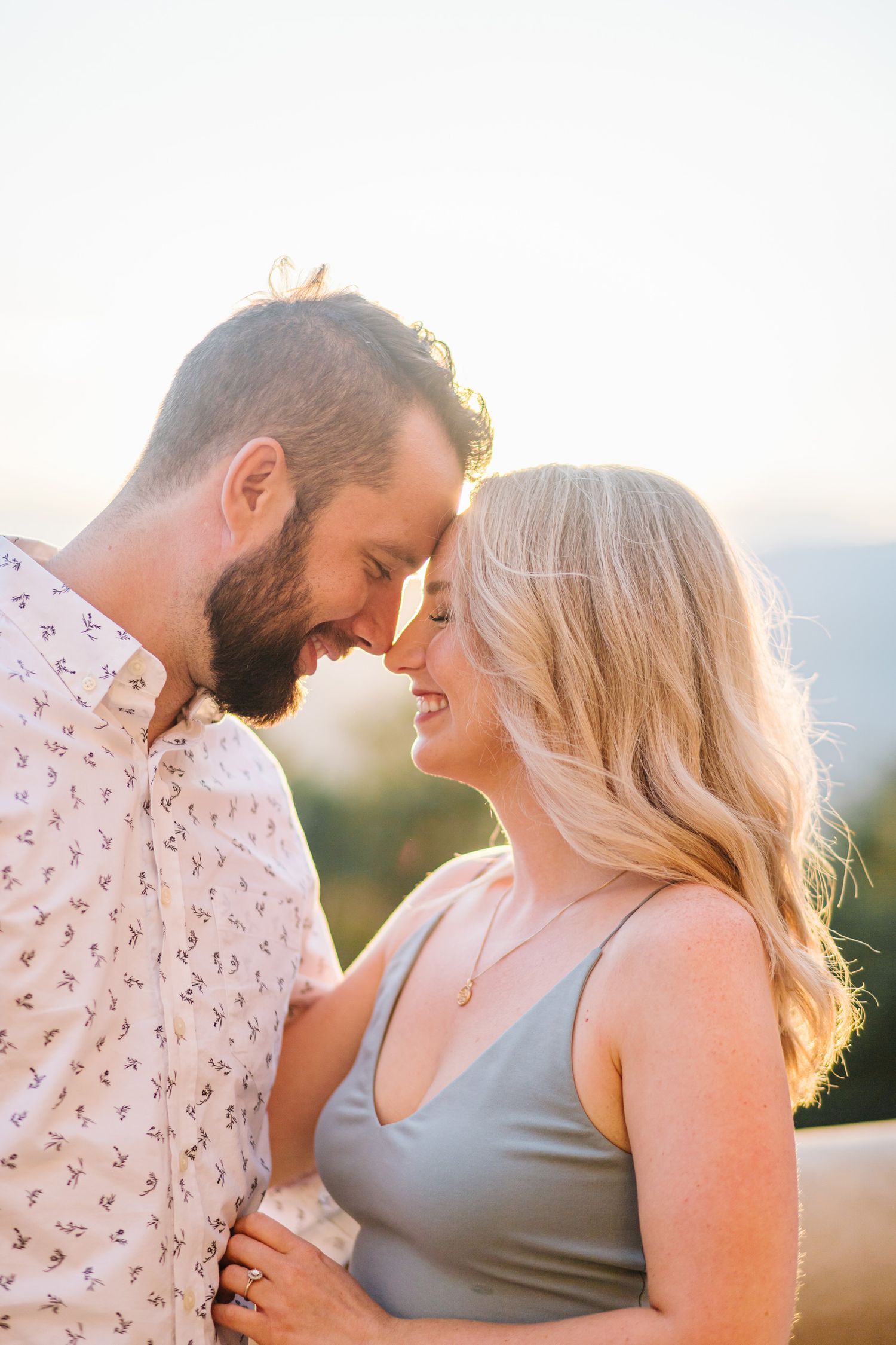 Intimate sunset portrait of couple laughing together outdoors.
